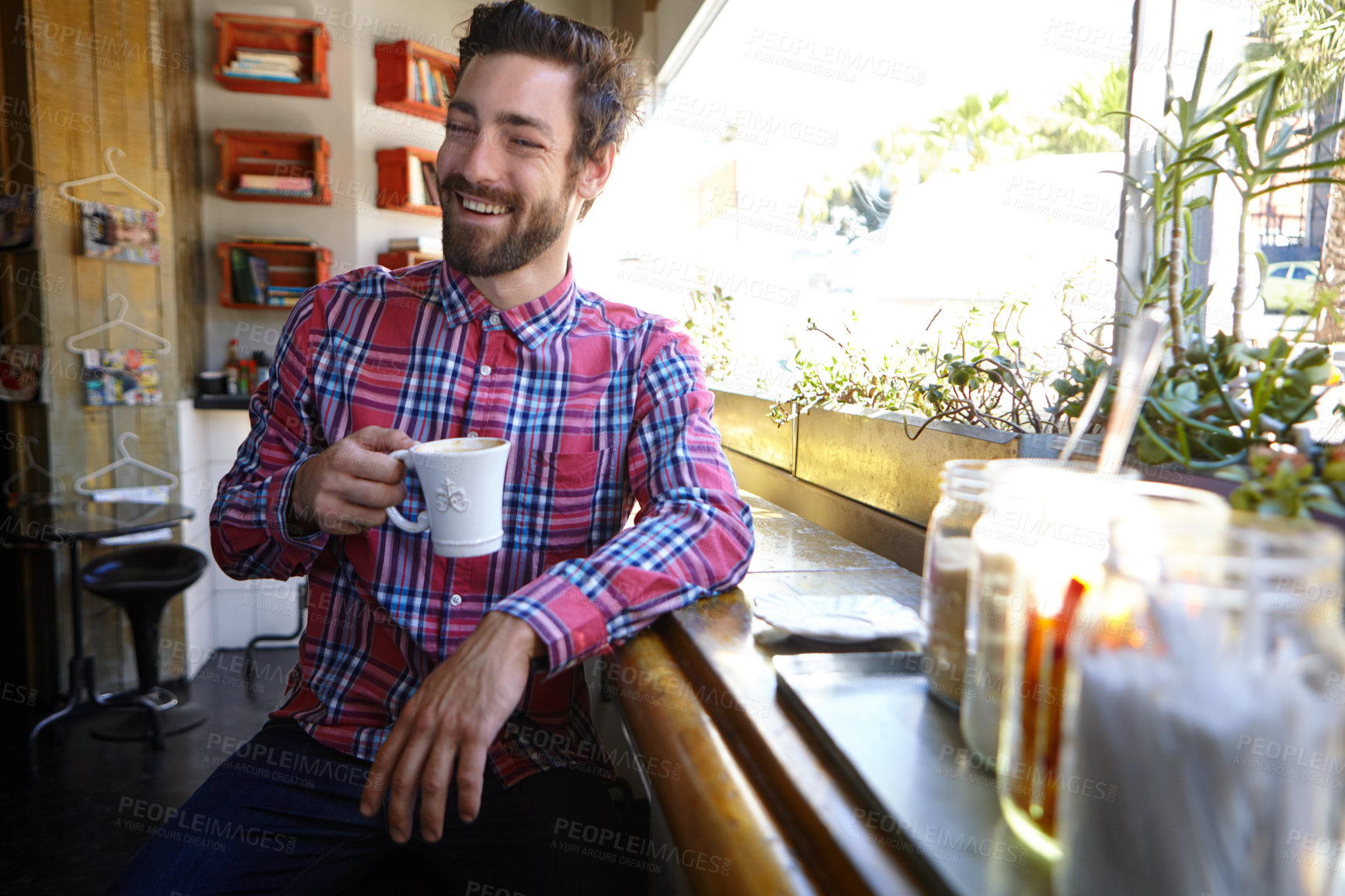 Buy stock photo Shot of a young man drinking a cup of coffee in a coffee shop