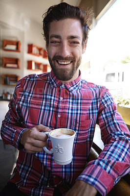 Buy stock photo Shot of a young man drinking a cup of coffee in a coffee shop