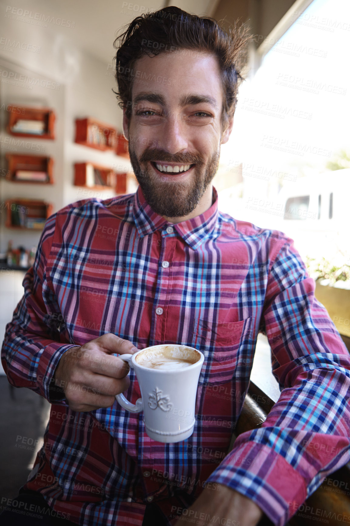 Buy stock photo Shot of a young man drinking a cup of coffee in a coffee shop