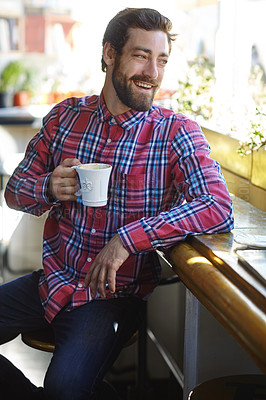 Buy stock photo Shot of a young man holding a cup of coffee in a cafe