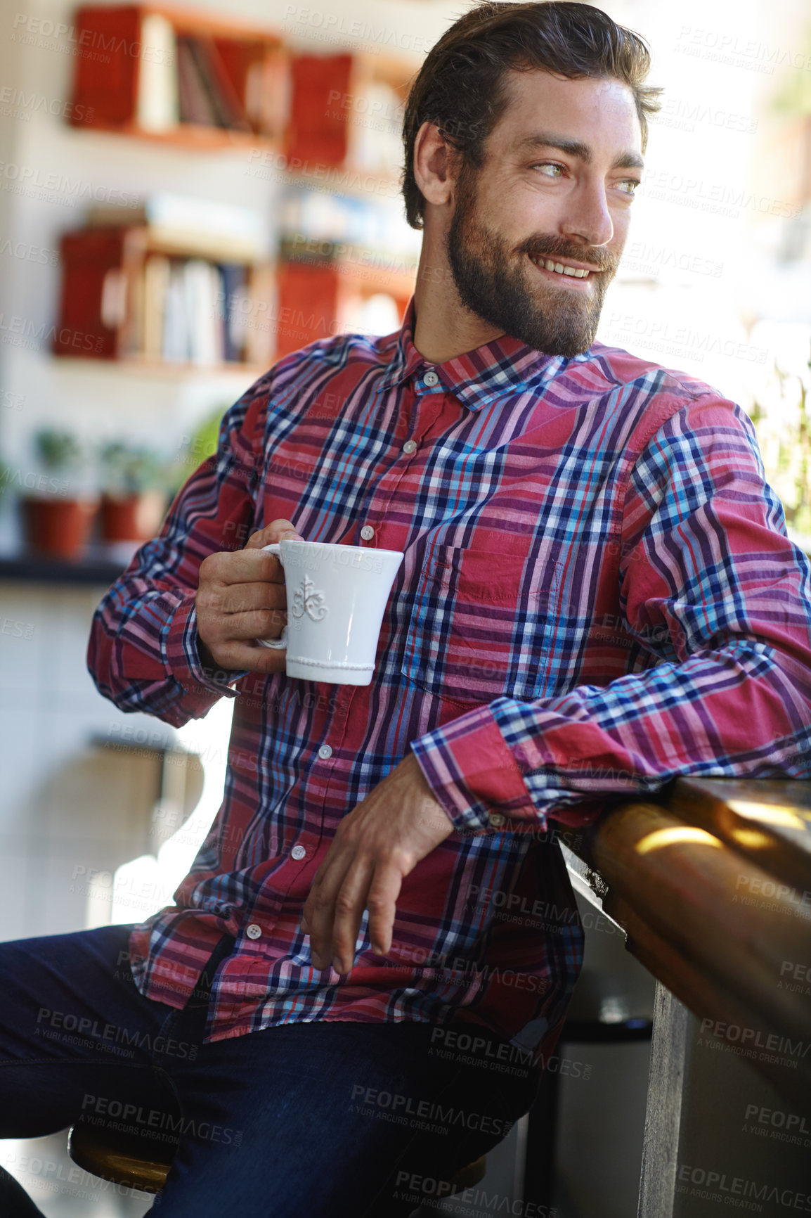 Buy stock photo Shot of a young man holding a cup of coffee in a cafe