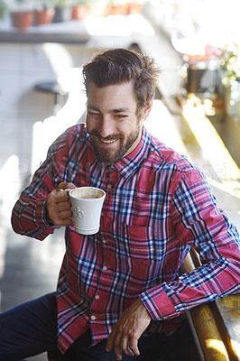 Buy stock photo Shot of a young man holding a cup of coffee in a cafe