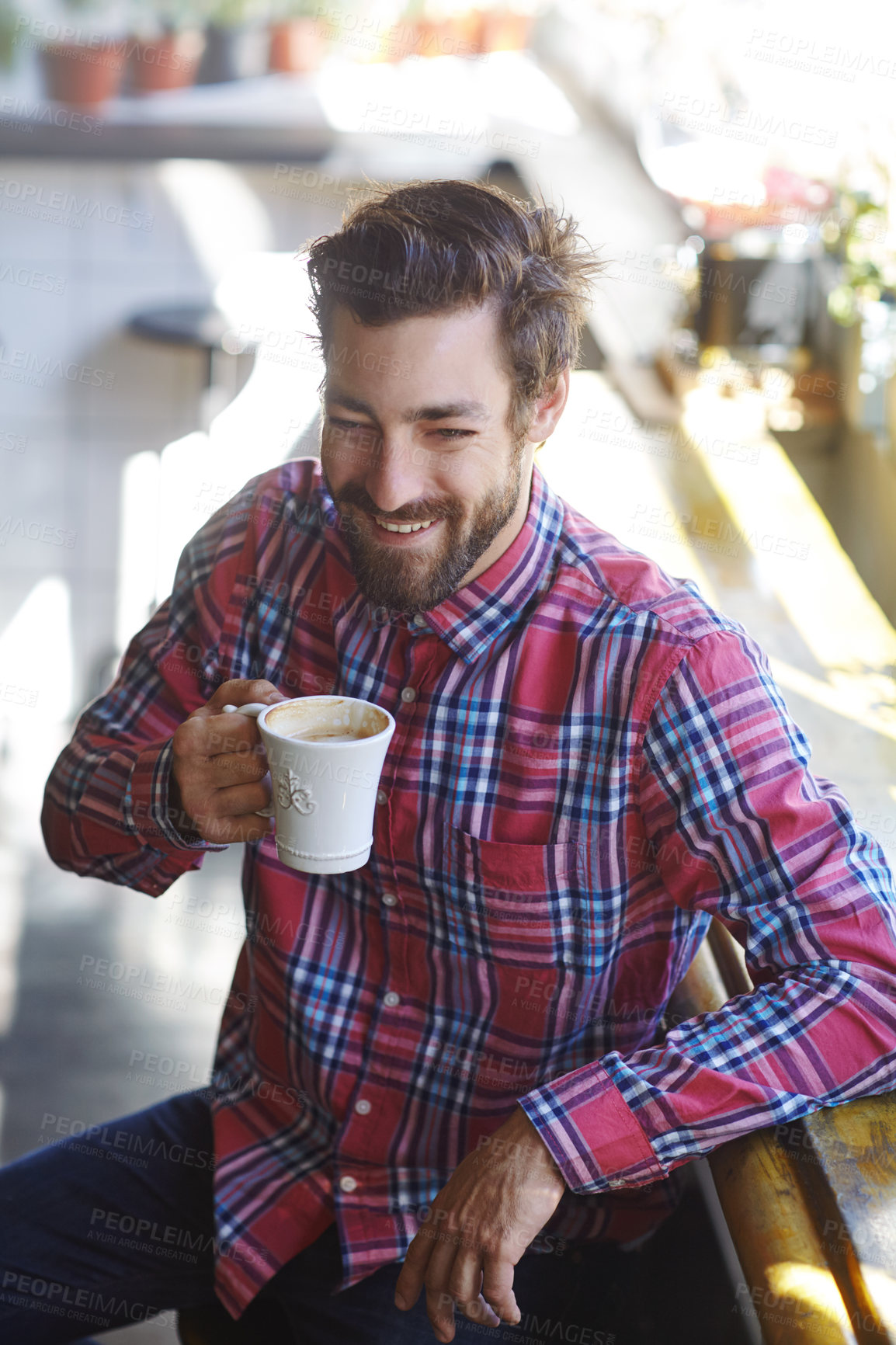 Buy stock photo Shot of a young man holding a cup of coffee in a cafe