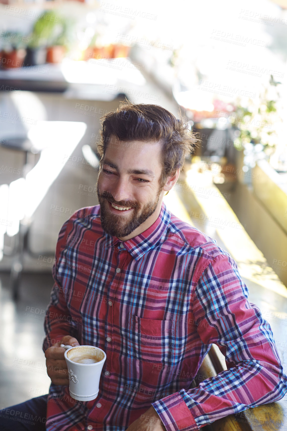 Buy stock photo Shot of a young man holding a cup of coffee in a cafe