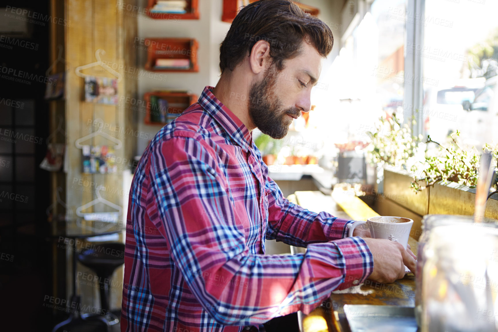 Buy stock photo Shot of a young man drinking coffee in a cafe