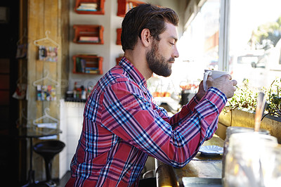 Buy stock photo Shot of a young man drinking coffee in a cafe