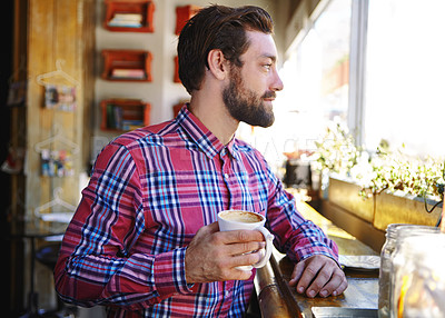 Buy stock photo Shot of a young man drinking coffee in a cafe