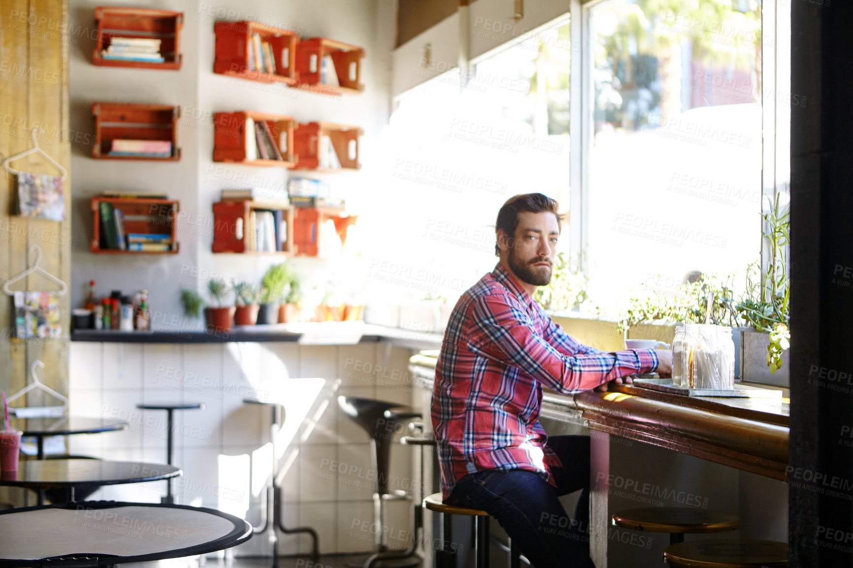 Buy stock photo Shot of a young man drinking coffee in a cafe