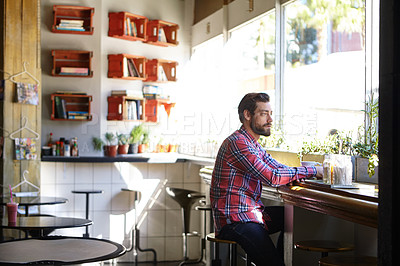 Buy stock photo Shot of a young man drinking coffee in a cafe