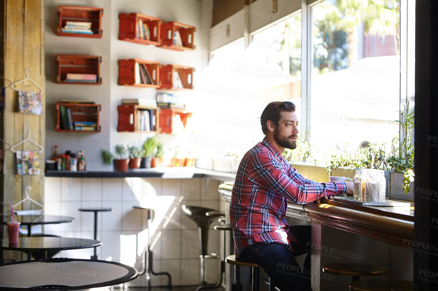 Buy stock photo Shot of a young man drinking coffee in a cafe