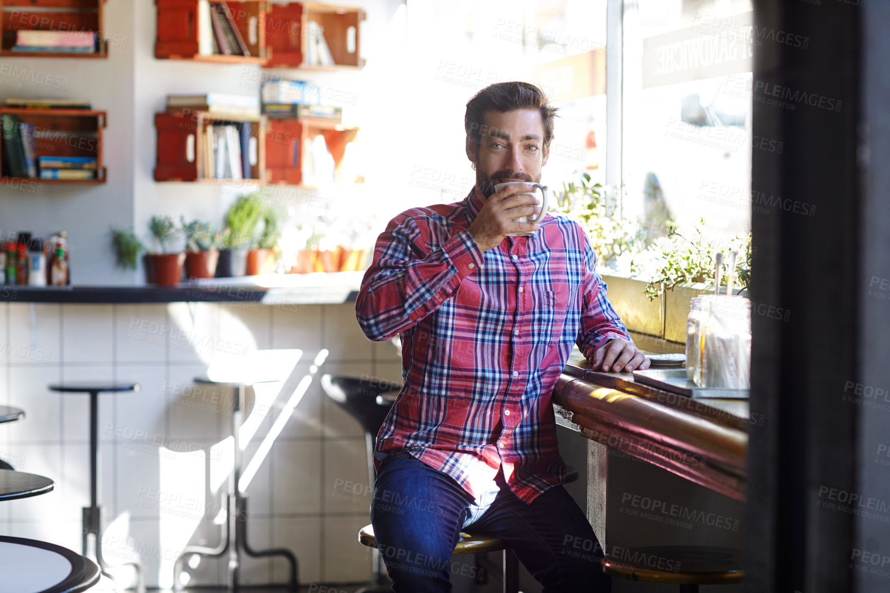 Buy stock photo Shot of a young man drinking coffee in a cafe