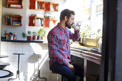 Buy stock photo Shot of a young man drinking coffee in a cafe