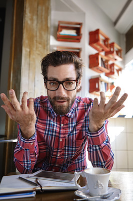 Buy stock photo Shot of a young man sitting in a coffee shop with his tablet and diary in front of him