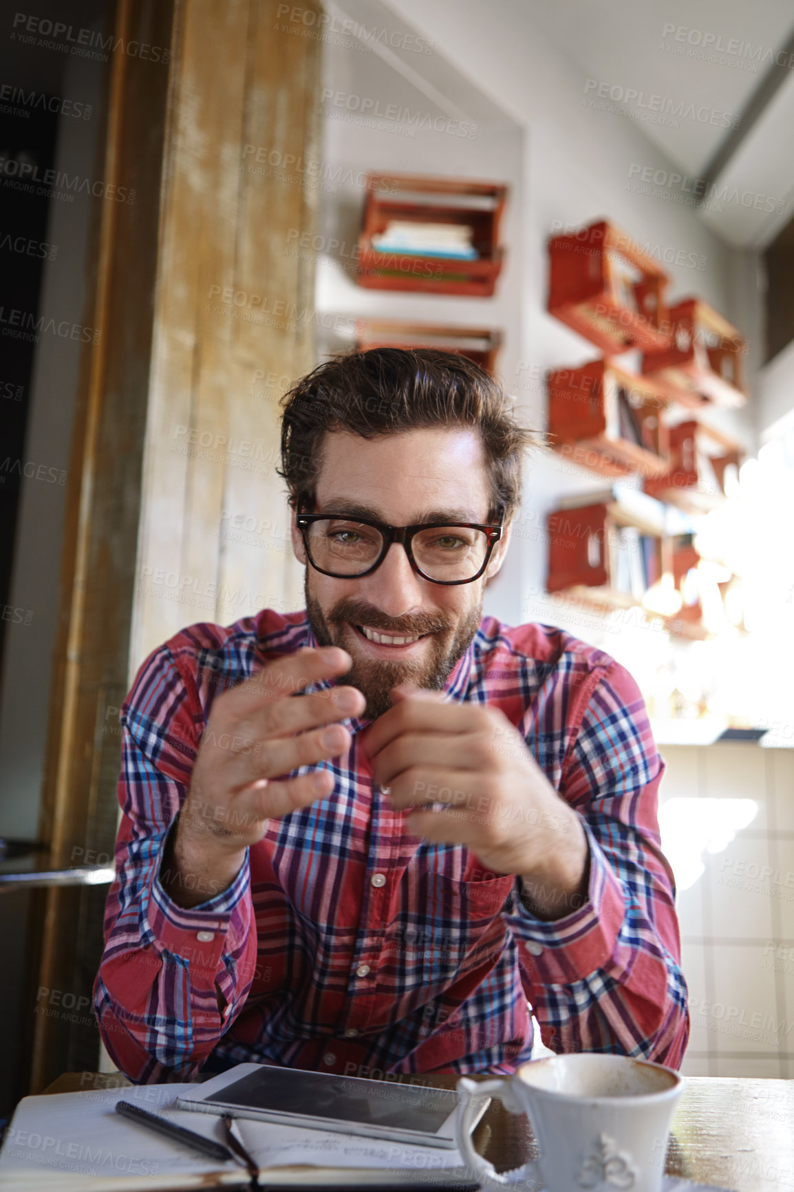 Buy stock photo Shot of a young man sitting in a coffee shop with his tablet and diary in front of him