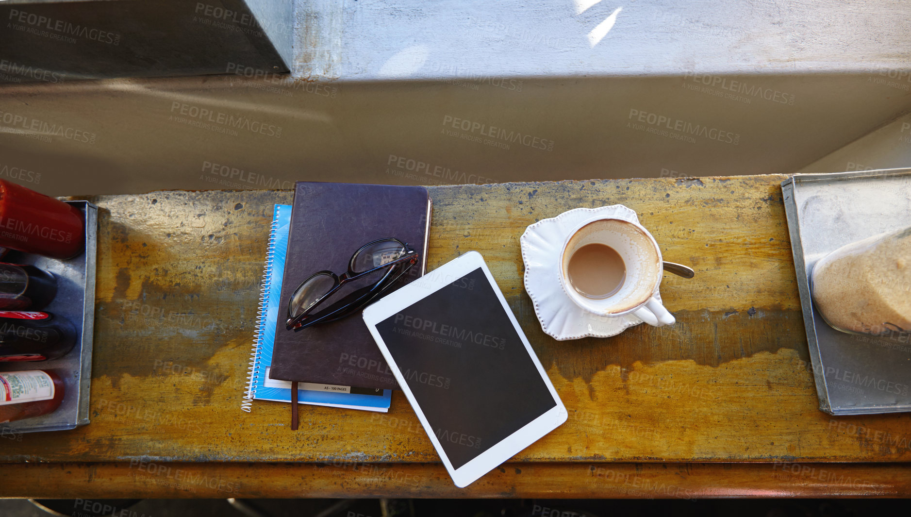 Buy stock photo High angle shot of a tablet, notebooks and coffee cup on a cafe counter