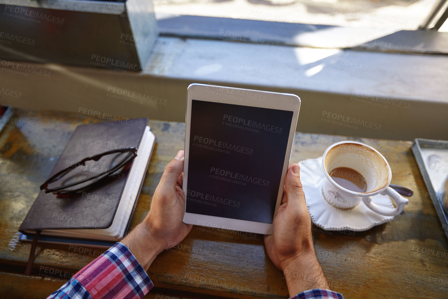 Buy stock photo Cropped shot of a man using a digital tablet at a cafe