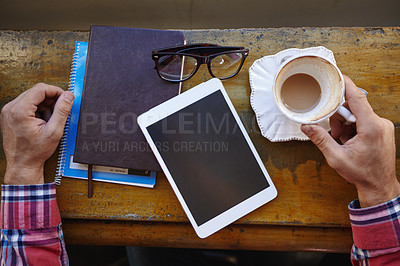 Buy stock photo High angle shot of man with a tablet, notebooks and coffee cup at a cafe counter