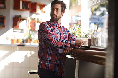 Buy stock photo Shot of a young man having a cup of coffee in a cafe