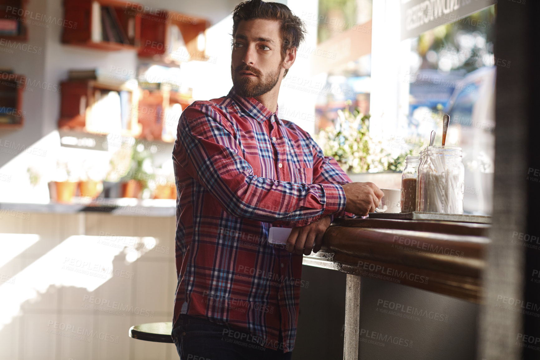 Buy stock photo Shot of a young man having a cup of coffee in a cafe