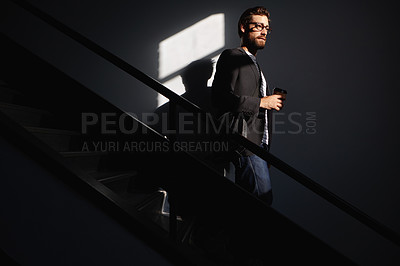 Buy stock photo Shot of a stylish and confident young man walking down a staircase