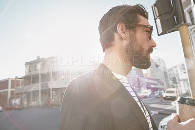 Buy stock photo Shot of a stylish young man having a coffee on the go in the city