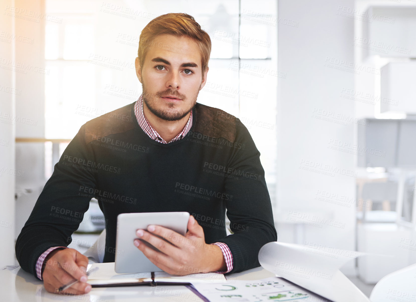 Buy stock photo Cropped portrait of a young businssman using a digital tablet at his desk in the office