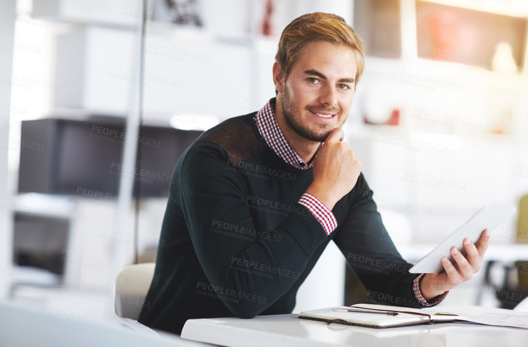Buy stock photo Cropped portrait of a young businssman using a digital tablet at his desk in the office