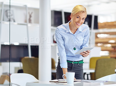 Buy stock photo Cropped portrait of a young businsswoman using a digital tablet at her desk in the office
