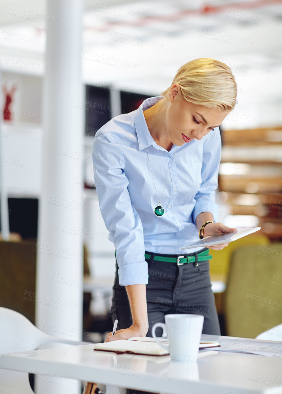 Buy stock photo Cropped shot of a young businsswoman using a digital tablet at her desk in the office