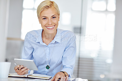 Buy stock photo Cropped portrait of a young businsswoman using a digital tablet at her desk in the office