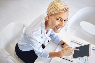 Buy stock photo High angle portrait of a young businsswoman using a digital tablet at her desk in the office
