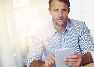 Buy stock photo Cropped portrait of a mature businssman using a digital tablet at his desk in the office
