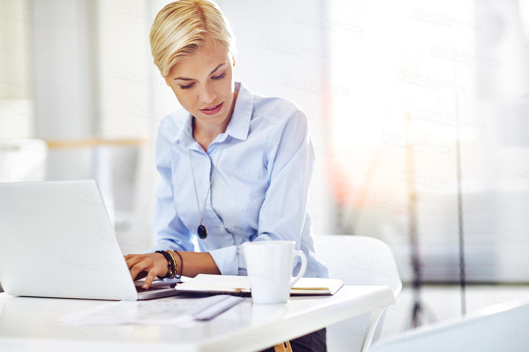 Buy stock photo Cropped shot of a young businesswoman using a laptop at her desk