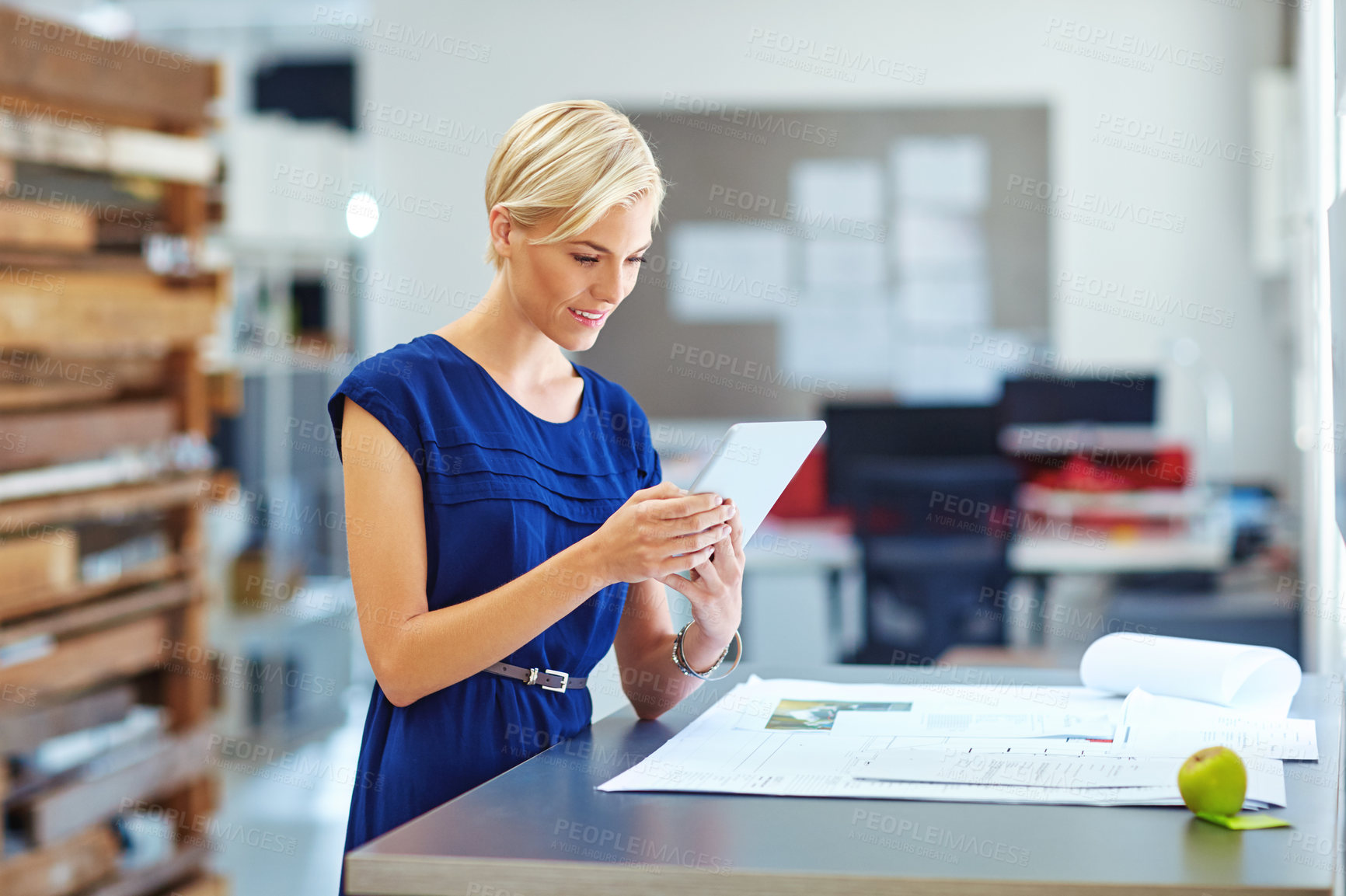 Buy stock photo Cropped shot of a young businesswoman working on her tablet in the office