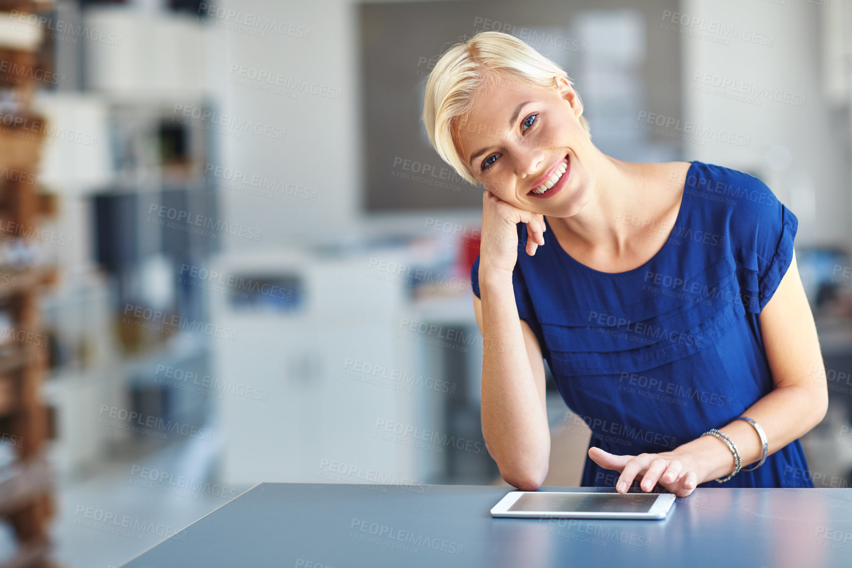 Buy stock photo Cropped portrait of a young businesswoman working on her tablet in the office