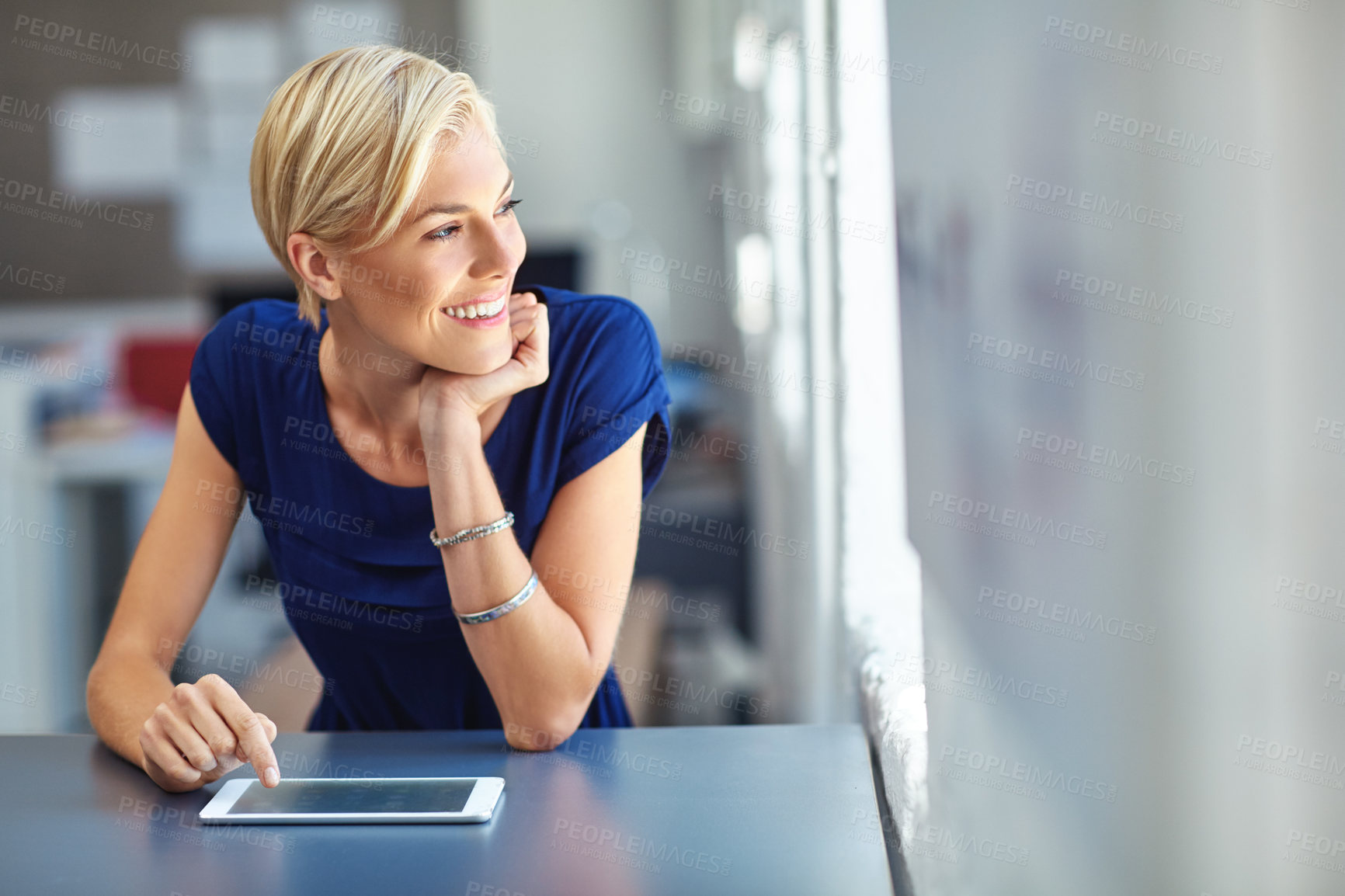 Buy stock photo Cropped shot of a young businesswoman working on her tablet in the office