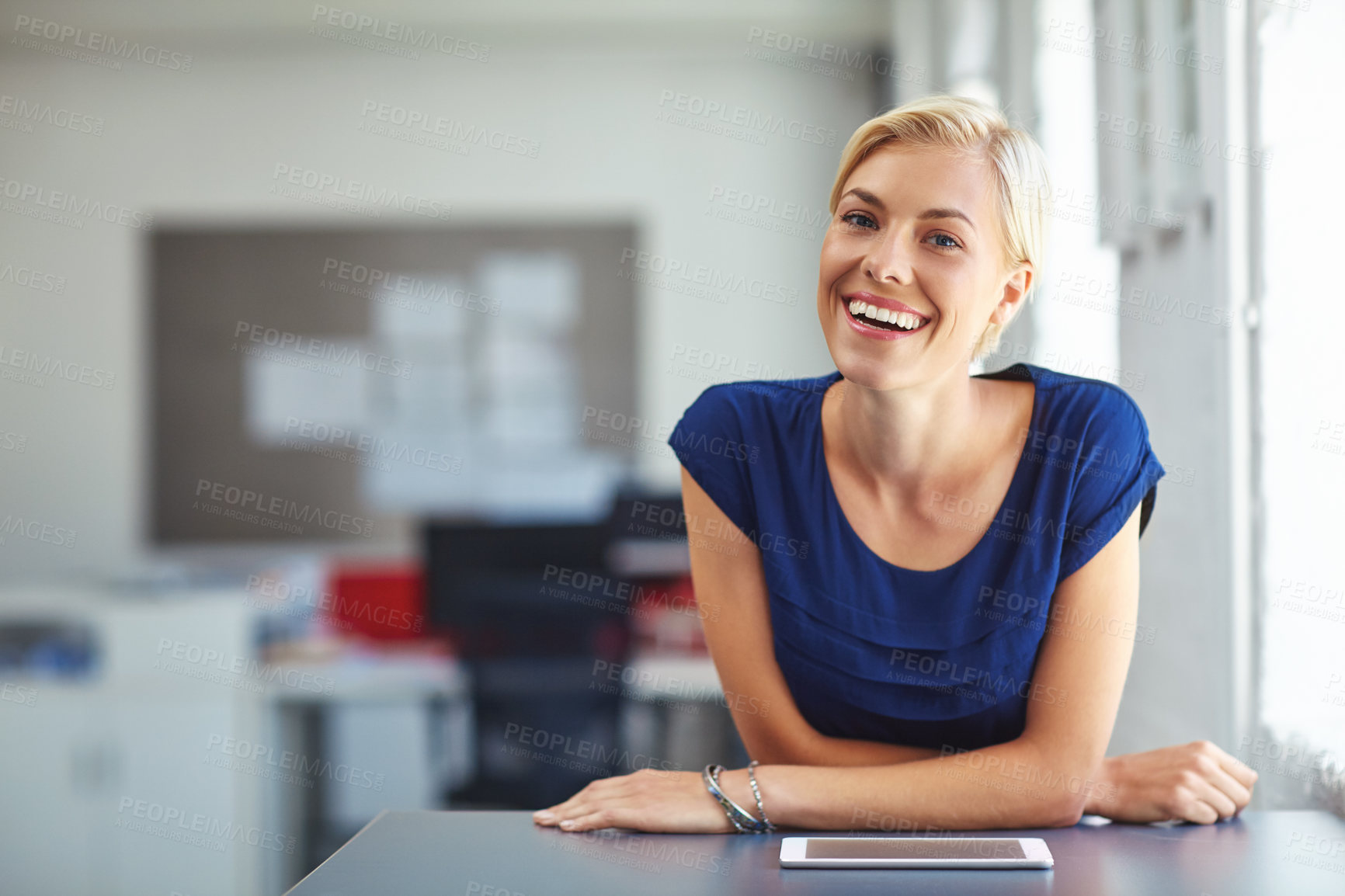 Buy stock photo Cropped portrait of a young businesswoman working on her tablet in the office
