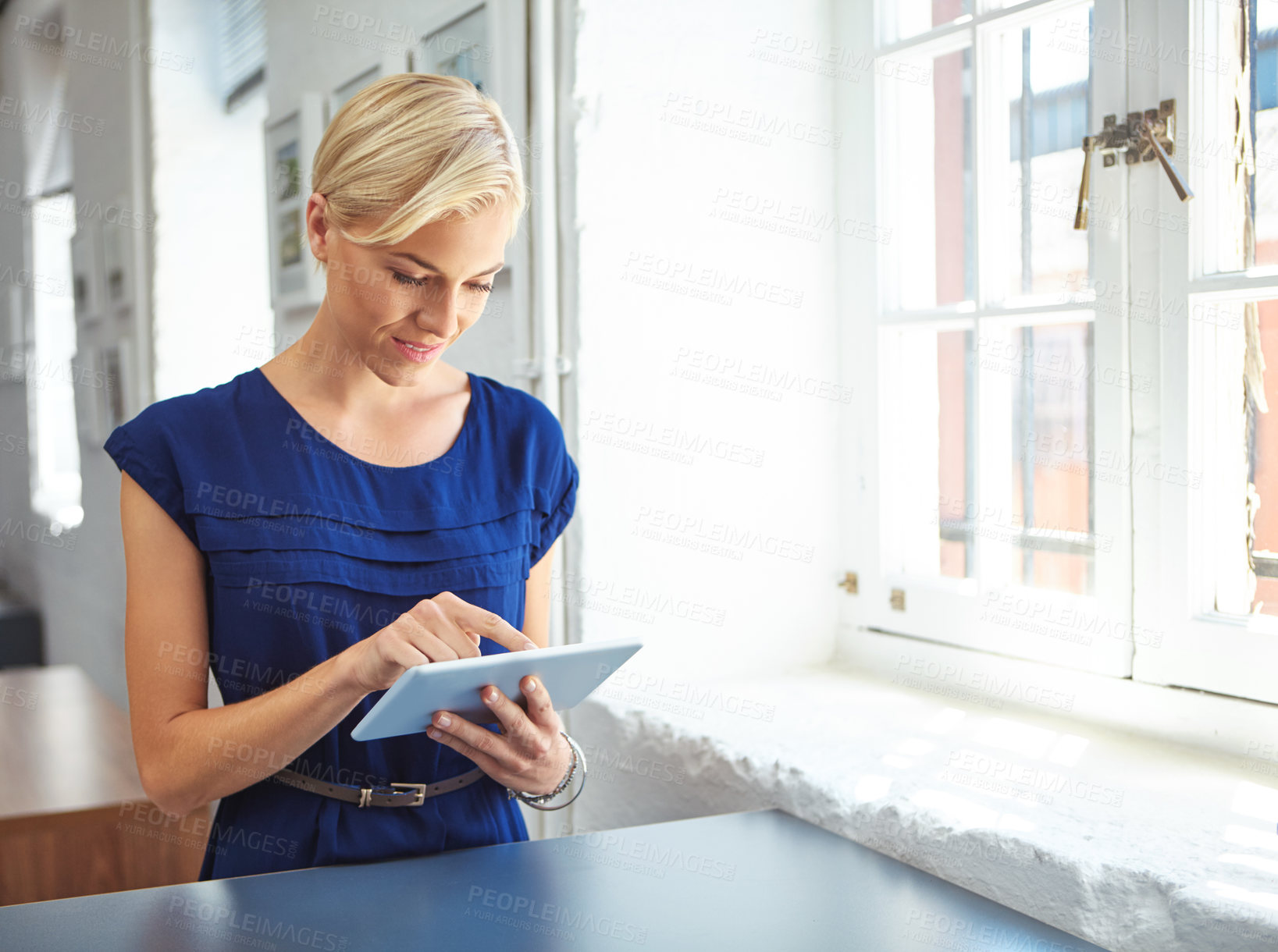 Buy stock photo Cropped shot of a young businesswoman working on her tablet in the office