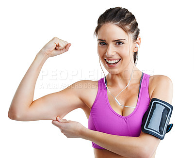 Buy stock photo Studio shot of a fit young woman flexing her muscles while wearing her mp3 armband