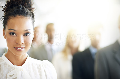 Buy stock photo Cropped portrait of a young businesswoman standing in her office with colleagues in the background