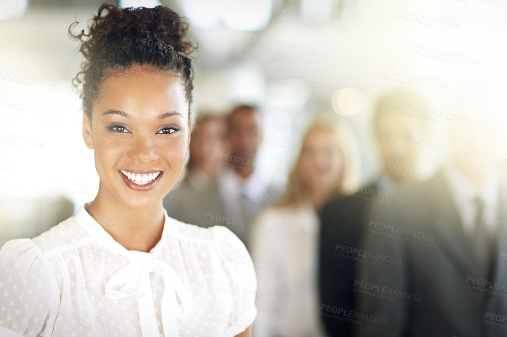 Buy stock photo Cropped portrait of a young businesswoman standing in her office with colleagues in the background