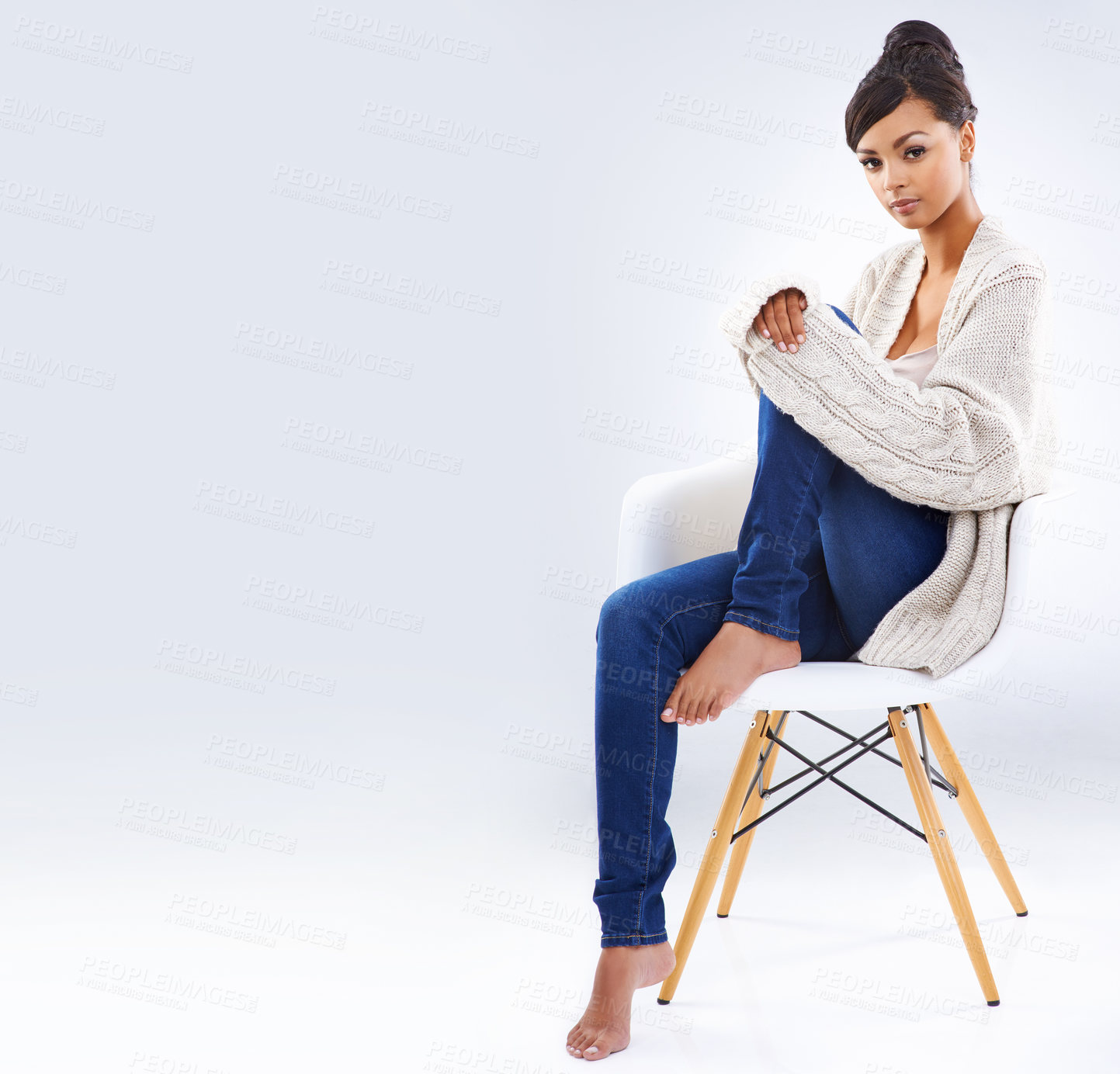 Buy stock photo Studio portrait of an attractive young woman sitting on a chair
