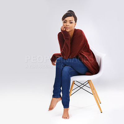 Buy stock photo Studio portrait of an attractive young woman sitting on a chair