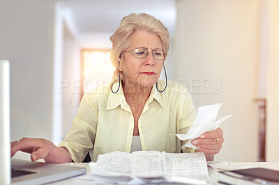 Buy stock photo Shot of a senior woman using her laptop to pay her bills online