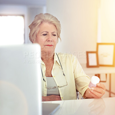 Buy stock photo Shot of a senior woman checking her medication at home