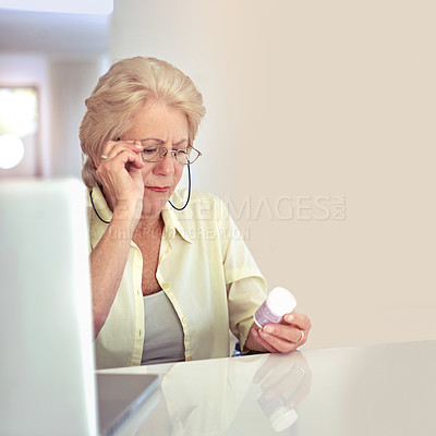 Buy stock photo Shot of a senior woman checking her medication at home