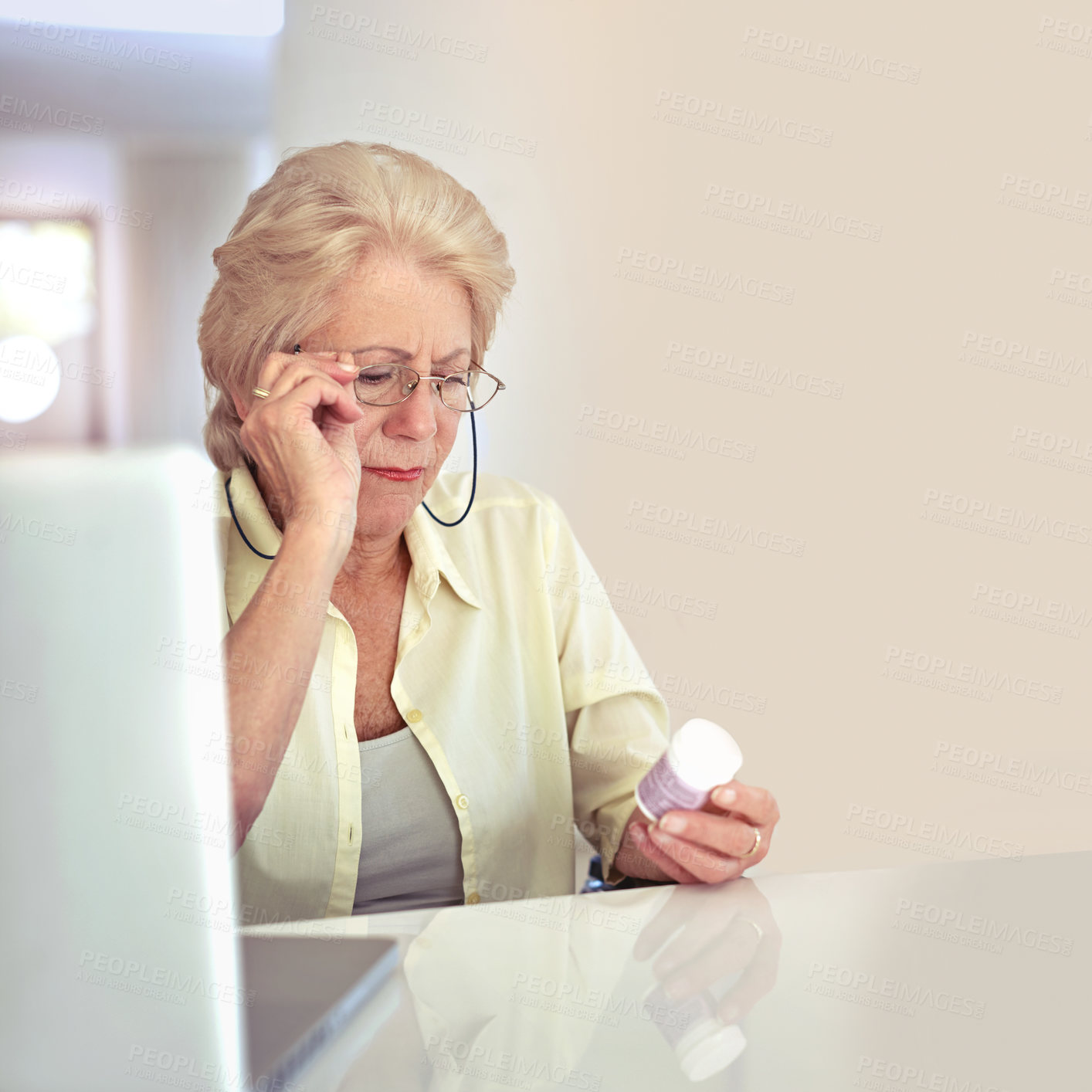 Buy stock photo Shot of a senior woman checking her medication at home