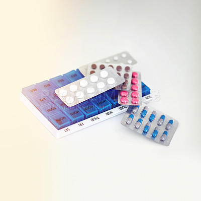 Buy stock photo Shot of various medications with a reminder container