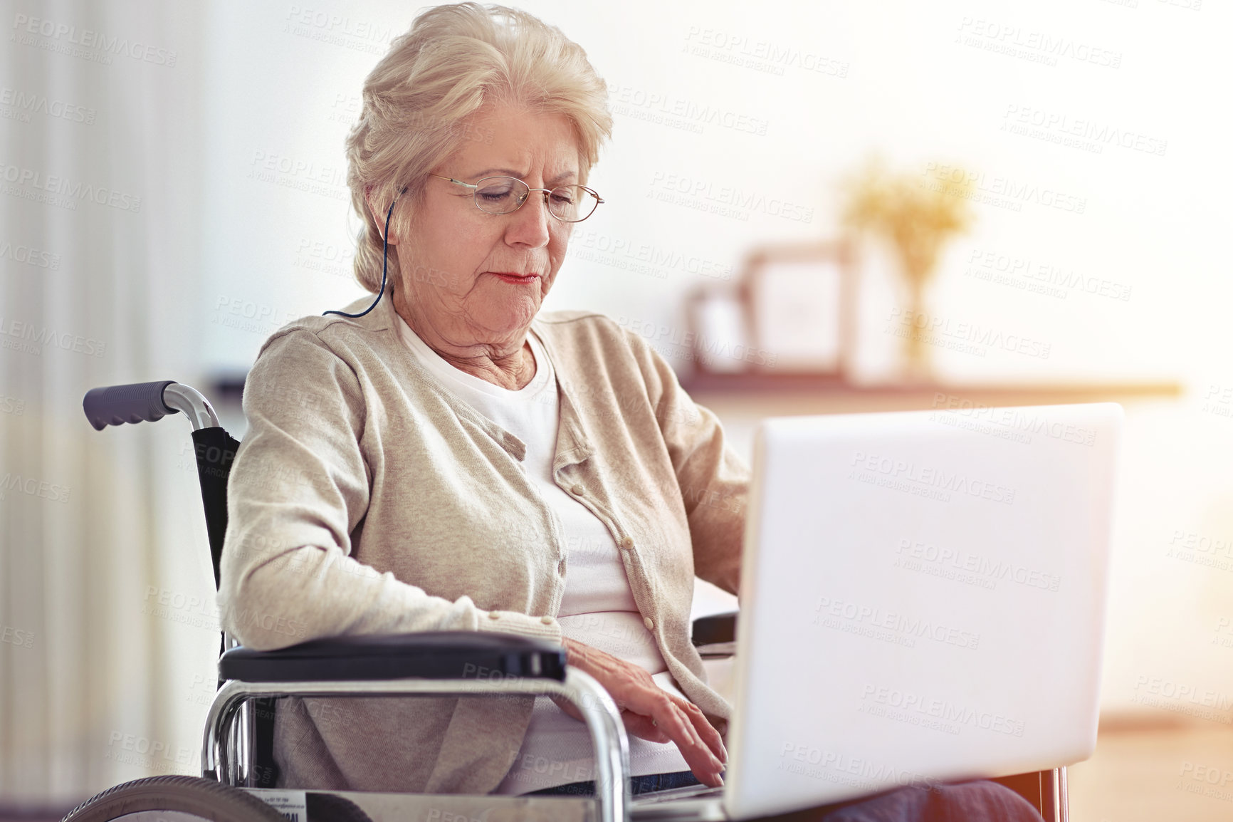 Buy stock photo Shot of a senior woman using a laptop while sitting in a wheelchair