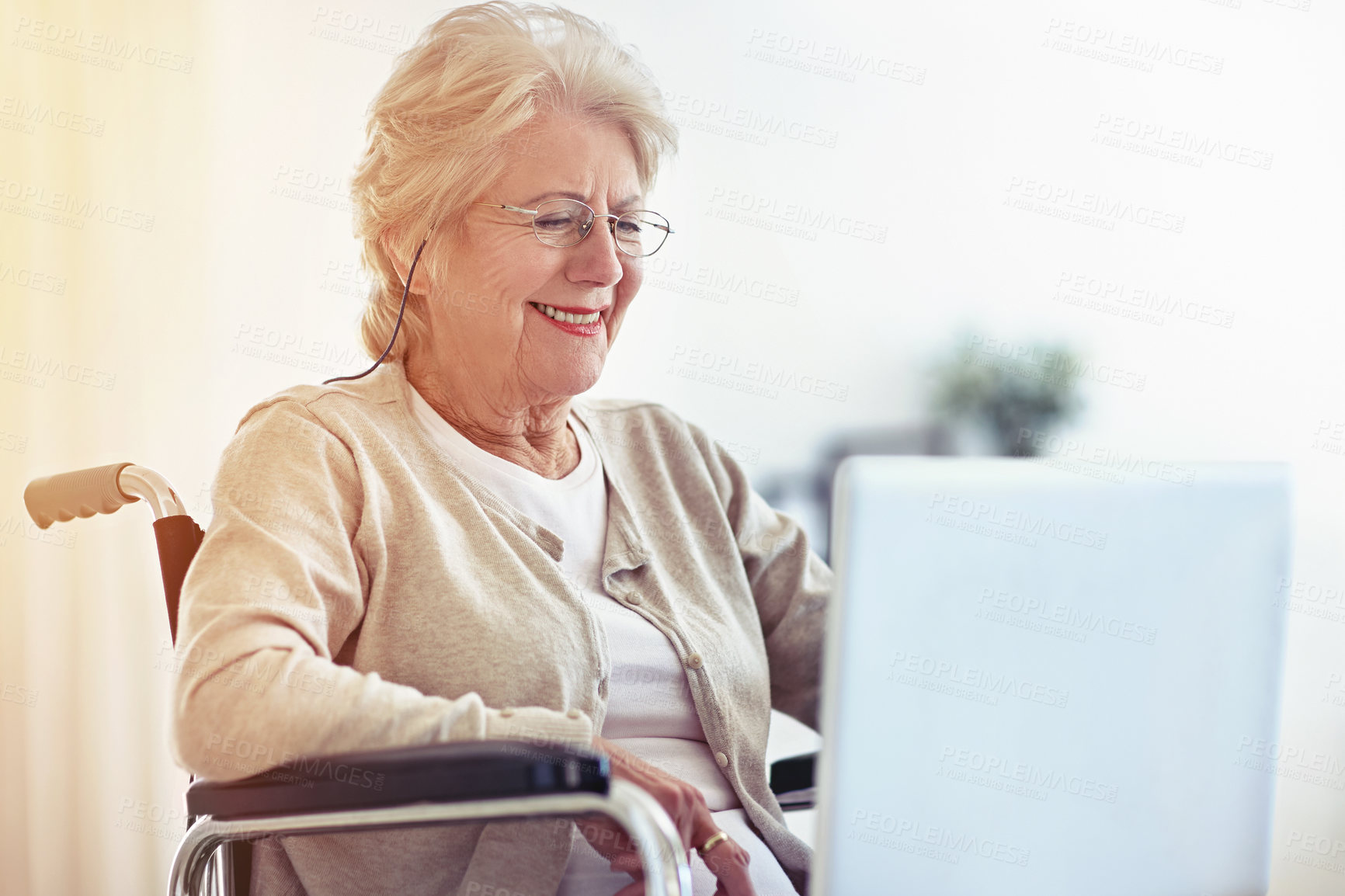 Buy stock photo Shot of a senior woman using a laptop while sitting in a wheelchair